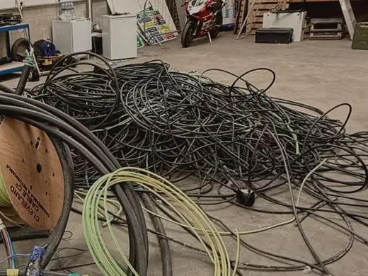 Coils of stripped cable and a cable drum on a warehouse floor