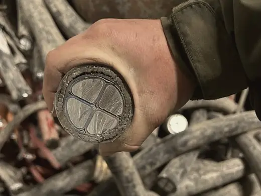 Gloved hand holding the cut face of a heavy multi-core cable